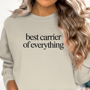 Crewneck sweatshirt with "best carrier of everything" text on chest.