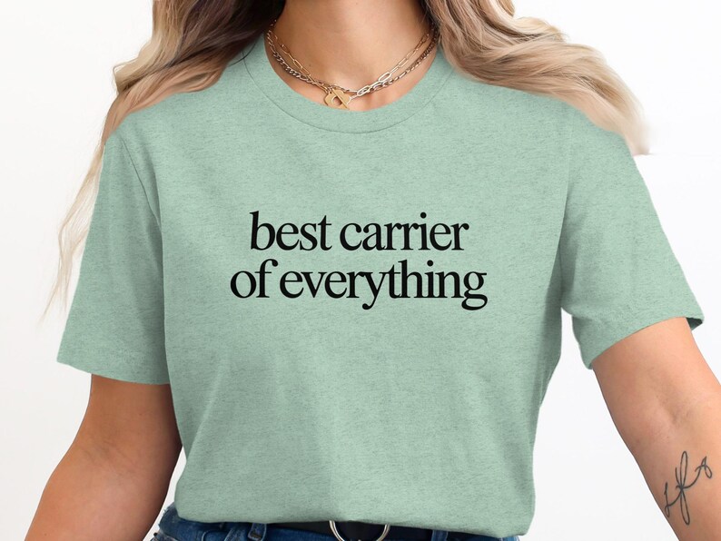 Pale green t-shirt with black text reading "best carrier of everything".