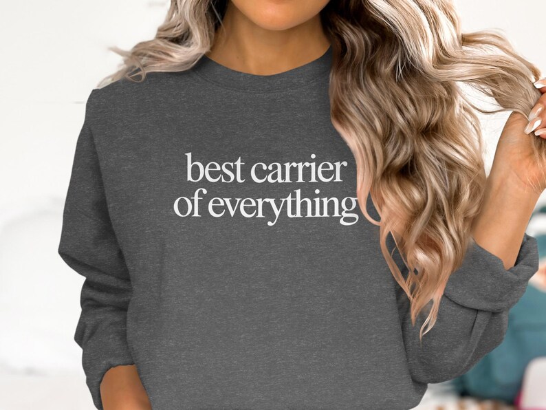 Dark gray crewneck sweatshirt with "best carrier of everything" text.