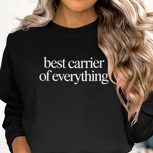 Black sweatshirt with "best carrier of everything" text in white.