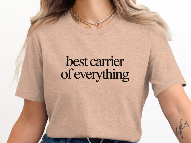 Peach t-shirt with "best carrier of everything" text in black.