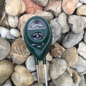 May include: A green three-way meter with probes for measuring moisture, light, and pH levels in soil. The meter has a dial with markings for each measurement type.