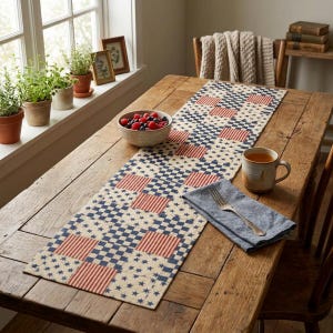 May include: A rustic wooden table is adorned with a patriotic-themed table runner featuring a pattern of red and white stripes, blue squares, and stars. A bowl of berries, a mug of tea, and a blue napkin with a fork complete the scene.