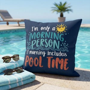 Könnte beinhalten: Marineblaues quadratisches Kissen mit dem Text "I'm only a MORNING PERSON if morning includes POOL TIME." Das Kissen liegt neben einem Stapel blau-weiß gestreifter Handtücher und zwei Sonnenbrillen.