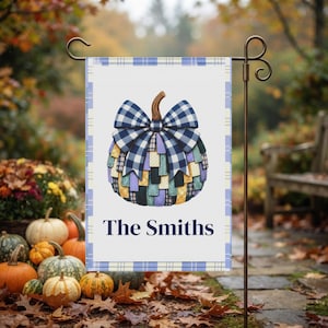 Peut inclure: Un drapeau de jardin rectangulaire à fond blanc avec une bordure à carreaux bleus. Au centre, une citrouille composée de pièces de tissu multicolores est surmontée d'un grand nœud vichy bleu et blanc. Le texte The Smiths est imprimé en dessous.
