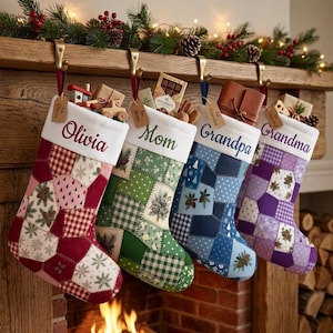 May include: Four personalized Christmas stockings hanging from a wooden mantel. Each stocking features a patchwork design with unique patterns, a white cuff with a name embroidered in script, and a small brown gift tag attached to the top.