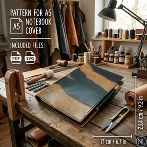 May include: A leather A5 notebook cover featuring a two-tone design of dark teal and tan panels. The cover measures 6.7 inches by 9.2 inches. Text on the image reads: PATTERN FOR A5 NOTEBOOK COVER, INCLUDED FILES: PDF, SVG. Tools are visible nearby.