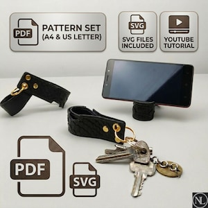 Può includere: Un supporto per telefono e portachiavi in pelle nera testurizzata con rivetti e anelli in metallo dorato. Il set include uno smartphone appoggiato sul supporto, un mazzo di chiavi in metallo e icone digitali per modelli PDF, file SVG e tutorial.