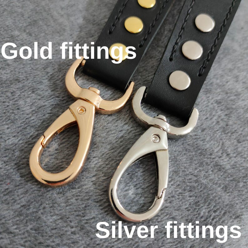 May include: Two leather straps with metal clasps. One strap has gold-colored hardware and the other has silver-colored hardware. "Gold fittings" and "Silver fittings" are written below the straps.