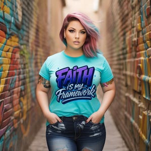 May include: A turquoise t-shirt with the text "Faith is my Framework" in a purple and blue gradient design. The person in the image is wearing dark blue denim jeans. The background is a brick alleyway with colourful graffiti.