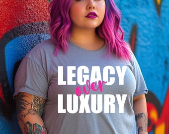 May include: A gray t-shirt with the text "LEGACY over LUXURY" in white and pink. The person in the image has purple and pink hair and tattoos on their arms. The background is a colorful graffiti wall.