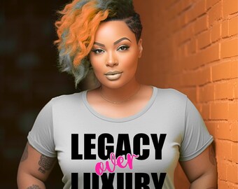 May include: A light gray t-shirt with the words "LEGACY over LUXURY" in black and pink. The person in the image has orange and gray hair and is leaning against an orange brick wall.