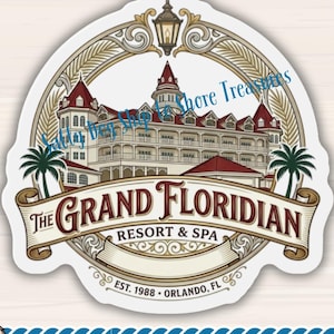 May include: A vinyl magnet featuring a detailed illustration of The Grand Floridian Resort & Spa with palm trees and a lantern. Below, a small white and brown dog wears a blue sailor hat and scarf. Text includes The Grand Floridian Resort & Spa.