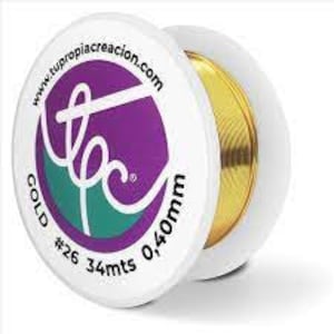 Può includere: Un rotolo di filo color oro, etichettato "COLD #26 34mts 0,40mm" e "www.tutopia creacion.com".