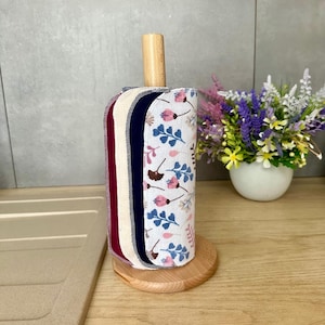 Cotton flannel unpaper towel roll with reusable paperless kitchen towels featuring a botanical print in pink, blue, and brown tones. Flannel naturally sticks to itself, so no buttons are needed to roll it up. Best stored wrapped around an empty paper towel roll. A perfect farmhouse kitchen accessory and thoughtful zero waste gift.