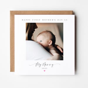 May include: A white card with the text "Happy First Mother's Day As My Nanny 2023" and a photo of a woman holding a baby.