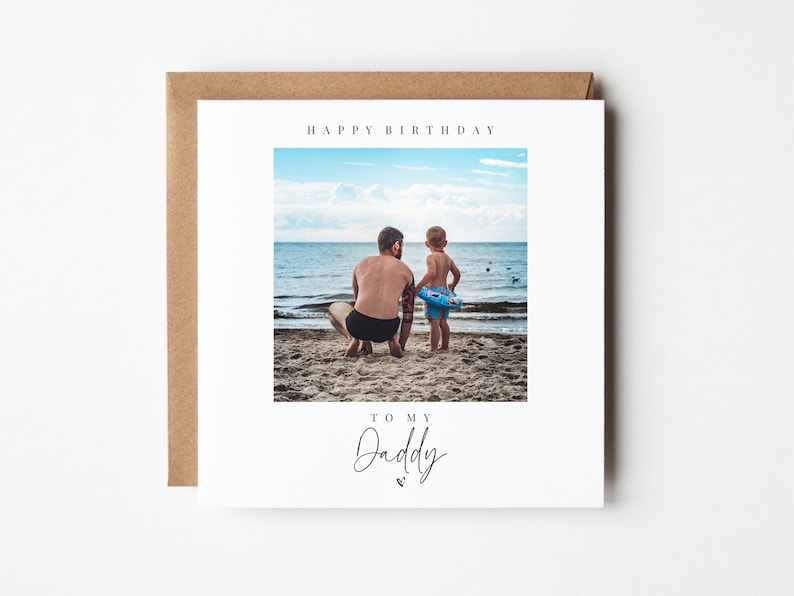 Puede incluir: Una tarjeta blanca con una foto de un padre y un hijo en la playa. La tarjeta dice "Feliz cumplea&ntilde;os" y "A mi pap&aacute;" con un coraz&oacute;n.