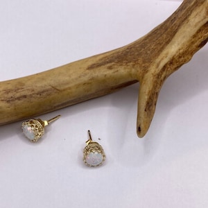 May include: A pair of gold earrings with white opal stones set in a delicate filigree design.