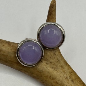 Puede incluir: Un par de pendientes de plata con piedras redondas de color lavanda.