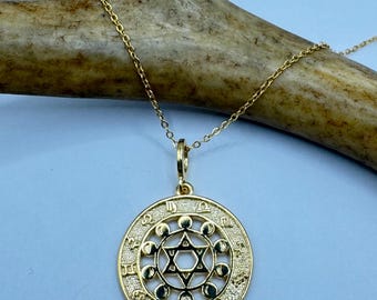 Peut inclure: Un collier en or avec un pendentif rond représentant une étoile de David entourée d'un cercle de symboles du zodiaque et de phases lunaires.