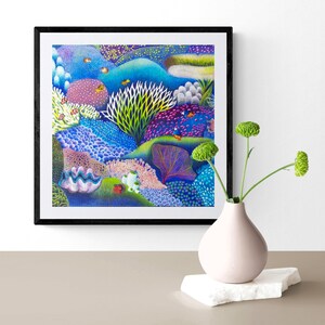 May include: A framed print of a colorful underwater scene with coral reefs, fish, and other marine life. The print is set against a white background and is framed in black.