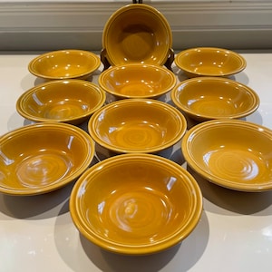 May include: A set of ten yellow ceramic bowls. The bowls are all the same size and shape, and they have a slightly rippled texture.