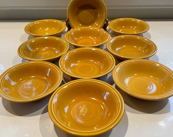 May include: A set of ten yellow ceramic bowls. The bowls are all the same size and shape, and they have a slightly rippled texture.