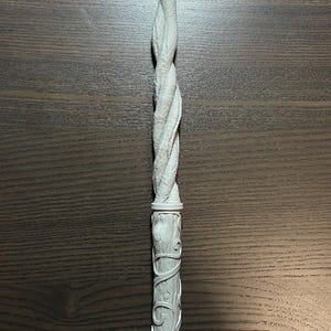 Peut inclure: Une baguette gris clair avec un motif torsadé. La poignée présente des détails sculptés et la tige a une texture en spirale. La baguette mesure environ 30 cm de long, idéale pour le cosplay ou les amateurs de fantaisie.