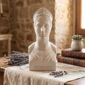 May include: A white matte bust sculpture of a person wearing a crown, with the name JOSEPHINE embossed on the base. The sculpture features detailed facial features and hair styling, presented as a solid, singular decorative object.