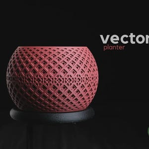 May include: A spherical, rose-colored planter featuring a complex, repeating geometric lattice pattern. The text 'vector' and 'planter' appear in the upper right, with a small circular 'h3liø design' logo in the bottom right corner.