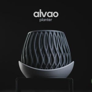 May include: A dark gray planter with a vertical wavy lattice pattern, resting in a smooth light gray curved base. The text alvao planter is centered above the object, and a small green circular logo with h3liø design is in the corner.