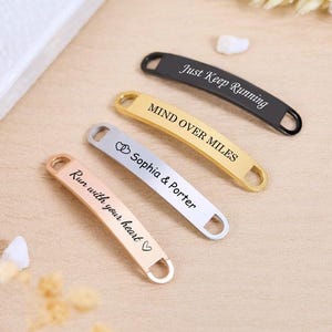 May include: Four metal shoe tags in black, gold, silver, and rose gold. The tags have text that reads "Just Keep Running", "Mind Over Miles", "Sophia & Porter", and "Run with your heart".