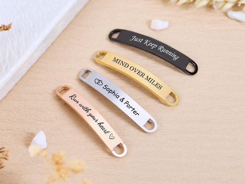 May include: Four metal shoe tags in black, gold, silver, and rose gold. The tags have text that reads "Just Keep Running", "Mind Over Miles", "Sophia & Porter", and "Run with your heart".