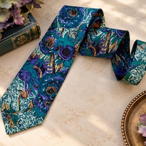 Peut inclure: Une cravate ornée d'un motif floral vibrant dans des tons de bleu sarcelle, bleu profond et violet. Le design présente des illustrations botaniques détaillées avec des centres sombres et un feuillage vert texturé sur un fond riche.