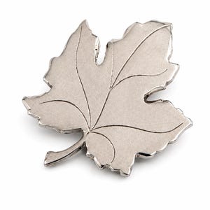 K&ouml;nnte beinhalten: Eine silberfarbene Brosche in Blattform. Die Brosche hat detaillierte Adern und eine strukturierte Oberfl&auml;che. Das Blattdesign ist ein klassisches, von der Natur inspiriertes Accessoire, das sich eignet, jedem Outfit einen Hauch von Eleganz zu verleihen.