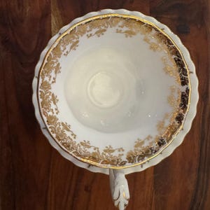 Puede incluir: Juego de taza y platillo blancos con detalles florales dorados. El borde y el asa est&aacute;n adornados con oro. La taza se apoya en un platillo a juego, ofreciendo una est&eacute;tica cl&aacute;sica y refinada.