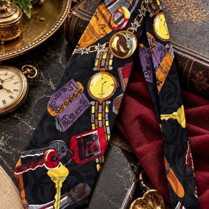May include: A black necktie featuring a repeating pattern of yellow keys, gold pocket watches, purple books, and red luggage tags. The fabric has a subtle tonal swirl design throughout, with various metallic and colorful illustrations printed across the surface.