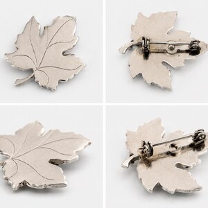 K&ouml;nnte beinhalten: Silberfarbene Brosche in Blattform. Die Brosche hat detaillierte Adern und einen Nadelverschluss auf der R&uuml;ckseite. Ein von der Natur inspiriertes Accessoire.