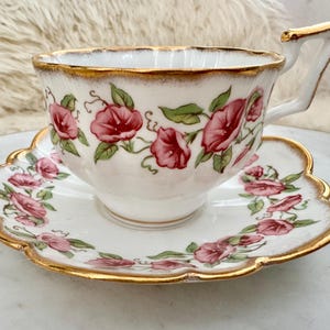 Puede incluir: Juego de taza y platillo de t&eacute; blanco con dise&ntilde;o floral rosa y ribetes dorados. La taza tiene un asa &uacute;nica. El platillo tiene un borde festoneado. Un elegante juego para la hora del t&eacute;.