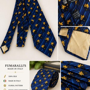 May include: A navy blue silk tie with a floral pattern. The tie features yellow flower designs and blue stripes. The label reads "Fumaralli's Made in Italy" and "100% Silk". The tie is in excellent condition.
