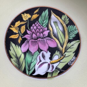 May include: A black and white floral design with pink, yellow, and green accents. The design is surrounded by a gold border and the signature "A.Bentille" is visible in the lower right corner.