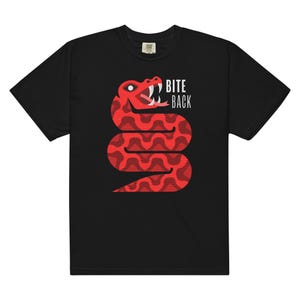 Può includere: T-shirt nero con una grafica di un serpente rosso e il testo "BITE BACK" in bianco.