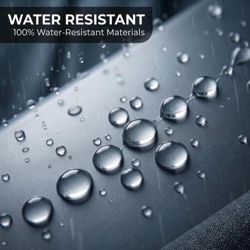 May include: A smooth, matte grey surface covered in clear water droplets, demonstrating water resistance. The text at the top reads WATER RESISTANT 100% Water-Resistant Materials. The surface texture is uniform and dark grey in colour.