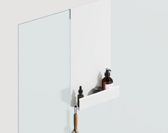 May include: A white shower shelf with a built-in shelf holding brown bottles and a small container. A wooden-handled brush hangs below. The shelf is mounted on a glass shower wall.