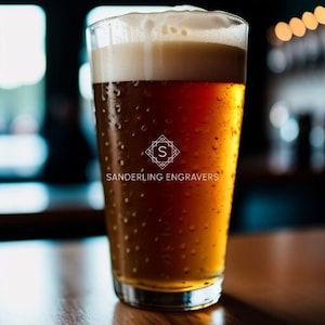 May include: A glass of amber-colored beer with a white head, condensation on the outside of the glass, and the text "Sanderling Engravers" on the glass.