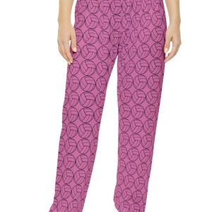 Puede incluir: Pantalón de pijama rosa con un estampado de voleibol negro.