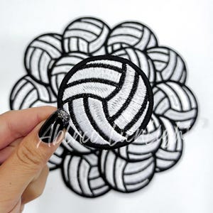 Puede incluir: Un conjunto de 10 parches de voleibol bordados en blanco y negro. Cada parche presenta un balón de voleibol blanco con costuras negras.