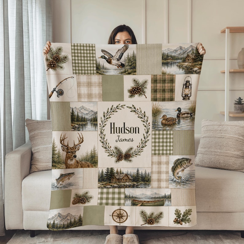 K&ouml;nnte beinhalten: Eine rechteckige Wohndecke im Patchwork-Design mit Naturmotiven wie einem Hirsch, Enten, einer Angelrute, einer Laterne, Tannenzapfen und einer H&uuml;tte. Das mittlere Feld zeigt einen Lorbeerkranz mit dem Schriftzug Hudson James.