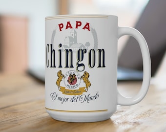 May include: White ceramic coffee mug with a design featuring the text "Papa Chingon" in black and red lettering. The design also includes a small illustration of a building and the text "Hecho en Mexico Limited Edition" in a red and white banner. The text "El mejor del Mundo" is printed below the banner.