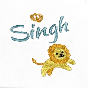 May include: A white onesie with blue embroidery that says "Singh" and a yellow embroidered lion with a crown above the name.